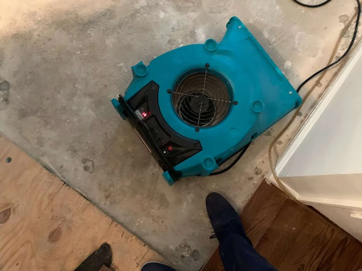 Air mover drying subfloor during Commercial Water Damage Restoration in Westlake
